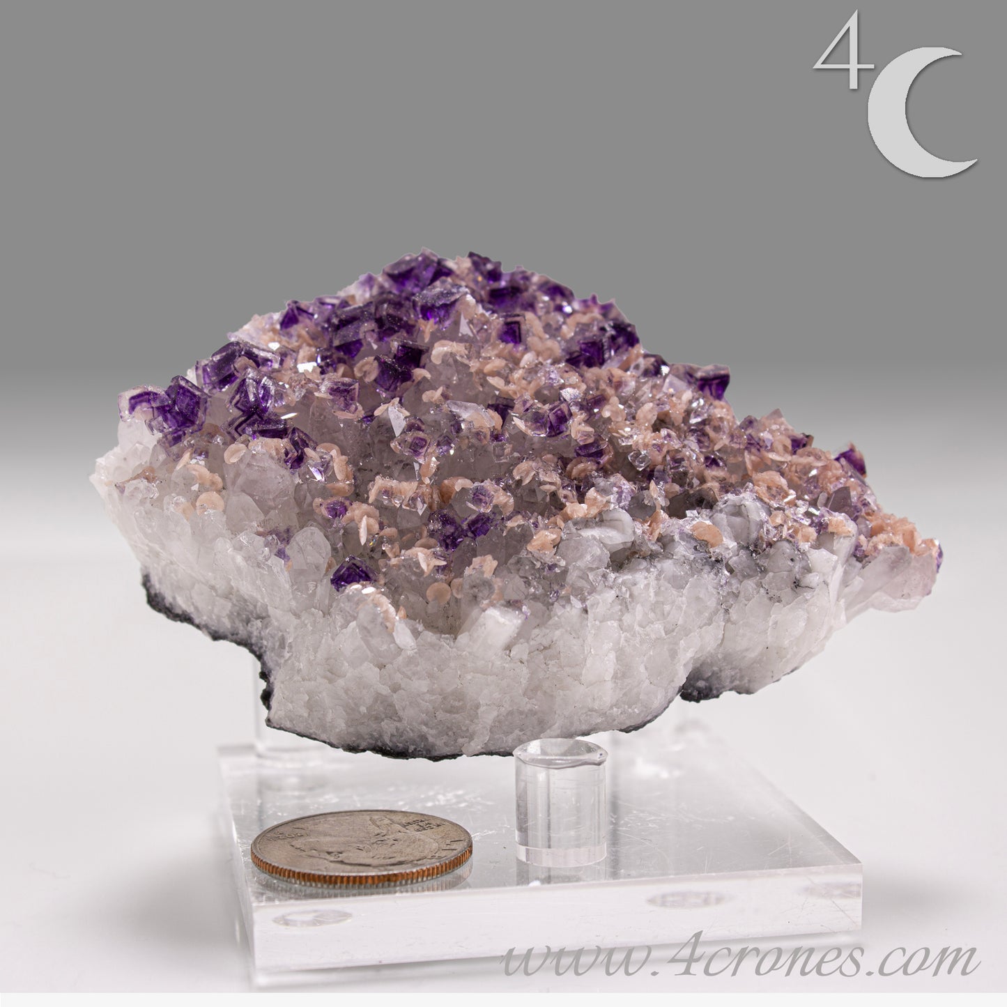 This exquisite specimen presents a rare and visually captivating combination: soft pink Rhodochrosite rosettes bloom across a sparkling bed of Quartz crystals, punctuated by sharply defined purple Fluorite cubes—some with phantom or window-like zoning.