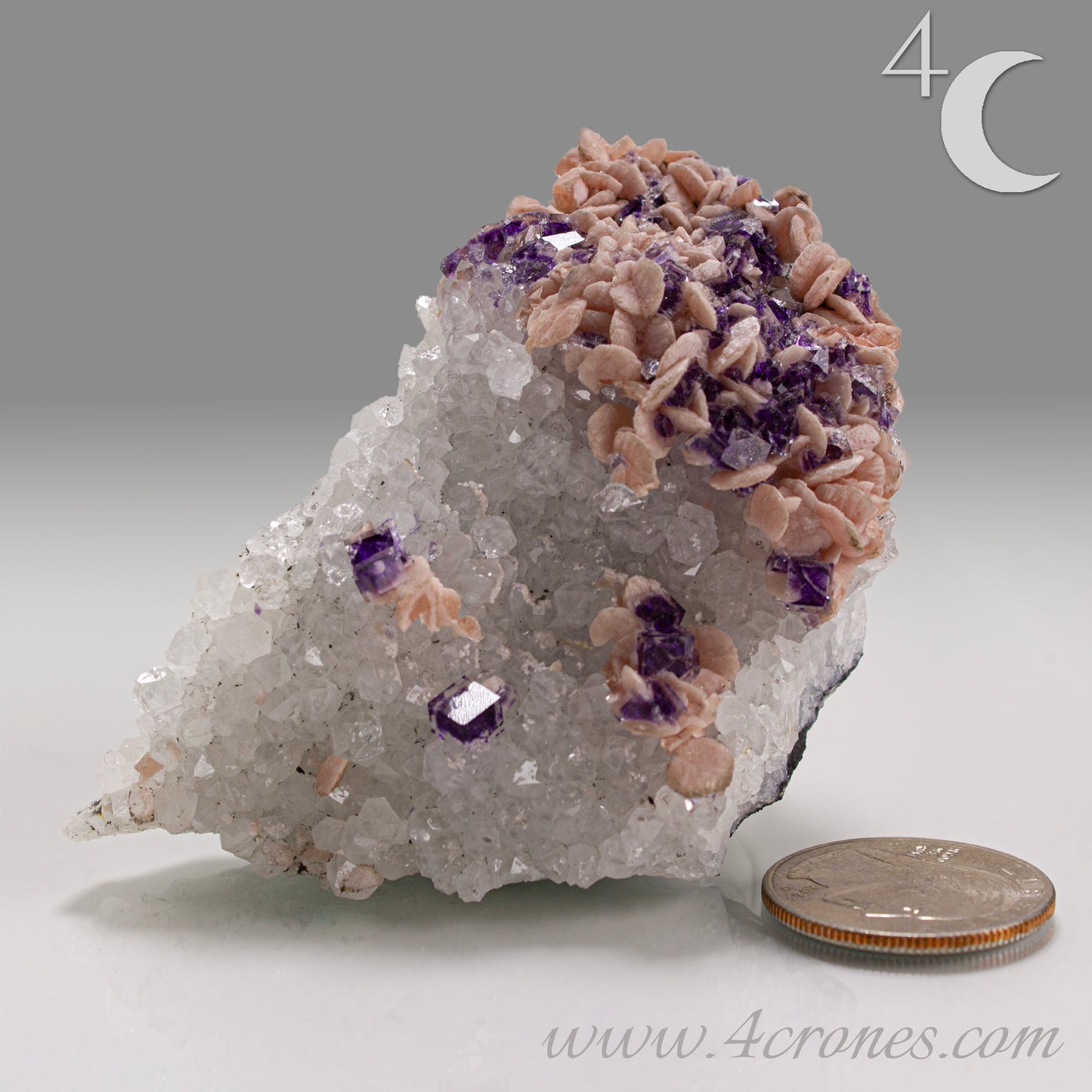 This exquisite specimen presents a rare and visually captivating combination: soft pink Rhodochrosite rosettes bloom across a sparkling bed of Quartz crystals, punctuated by sharply defined purple Fluorite cubes—some with phantom or window-like zoning.