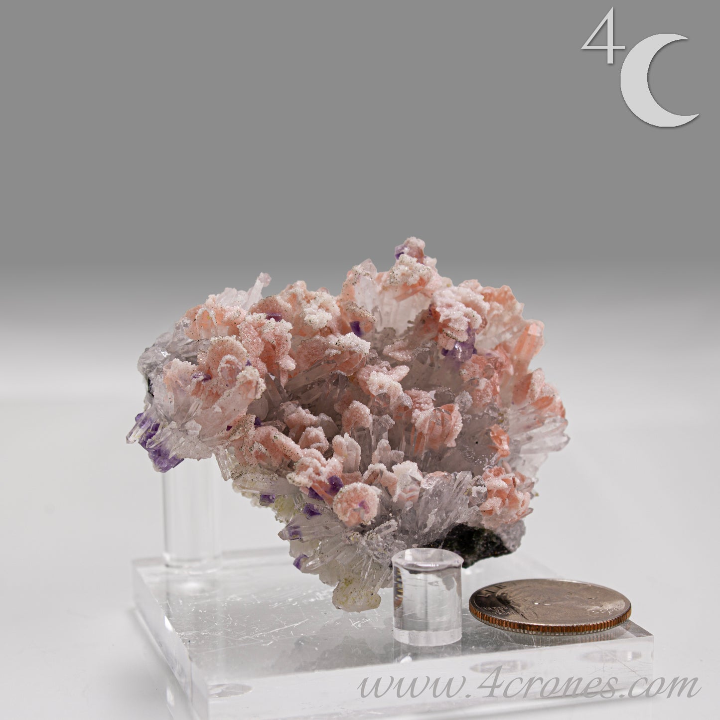 A delicate and visually dramatic specimen, this piece features pale pink Rhodochrosite dispersed among fine, radiating Quartz needles, with subtle inclusions of deep purple Fluorite.