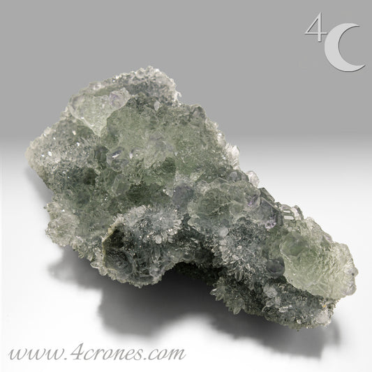 These beautiful green fluorites have enchanting delicate blue-purple phantoms. They are nestled in a dazzling bed of sparkling needle quartz and their subtlety and color shifts under various light sources create the feeling of being on a treasure hunt. Suddenly, another purple-blue phantom fluorite crystal appears amidst the crystal-clear twinkling needle quartz points. To top it off these amazing specimens glow and fluoresce a deep Lavendar under UV light. www.4crones.com