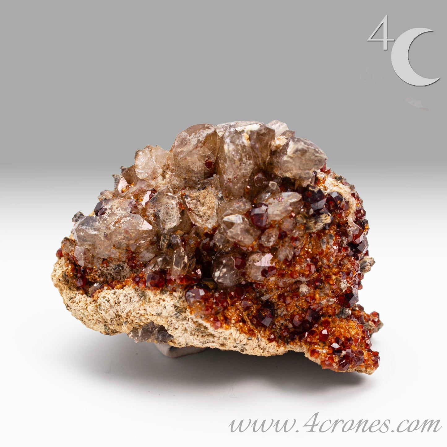 These gemmy Garnets are known as Spessartine Red Garnets, and they encrust and surround beautiful Smoky Quartz crystals on microcline feldspar matrices. The mine these specimens come from is known for the beautiful blingy red- and orange-colored garnets that they yield. www.4crones.com