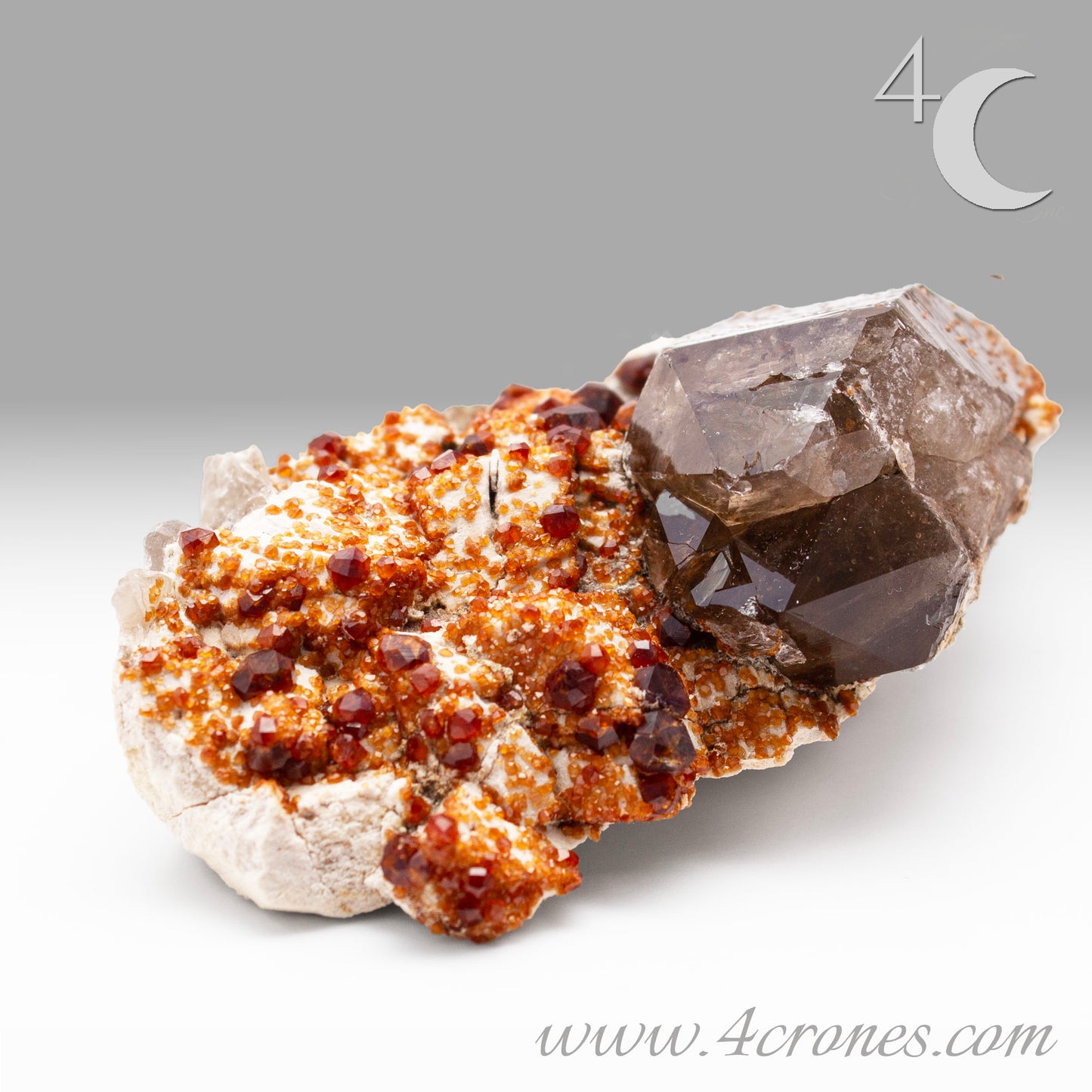 These gemmy Garnets are known as Spessartine Red Garnets, and they encrust and surround beautiful Smoky Quartz crystals on microcline feldspar matrices. The mine these specimens come from is known for the beautiful blingy red- and orange-colored garnets that they yield. www.4crones.com