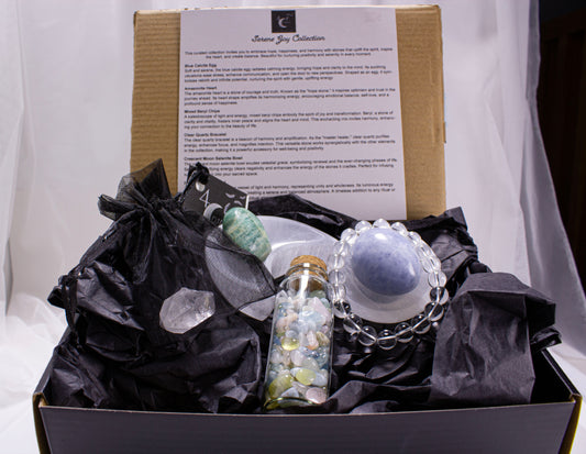 Glamorous gift box with decorative items including a bottle and crystal, on a white background.