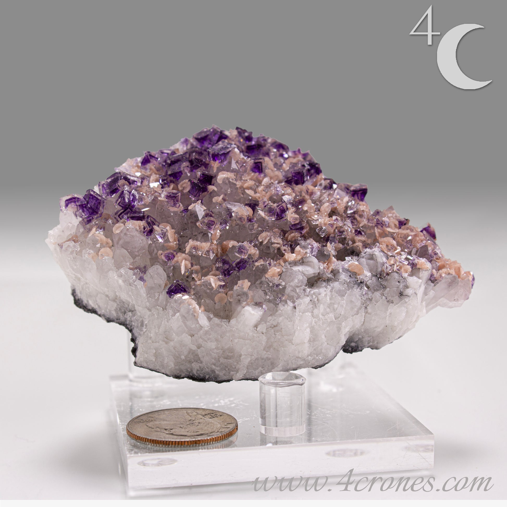 This exquisite specimen presents a rare and visually captivating combination: soft pink Rhodochrosite rosettes bloom across a sparkling bed of Quartz crystals, punctuated by sharply defined purple Fluorite cubes—some with phantom or window-like zoning. 