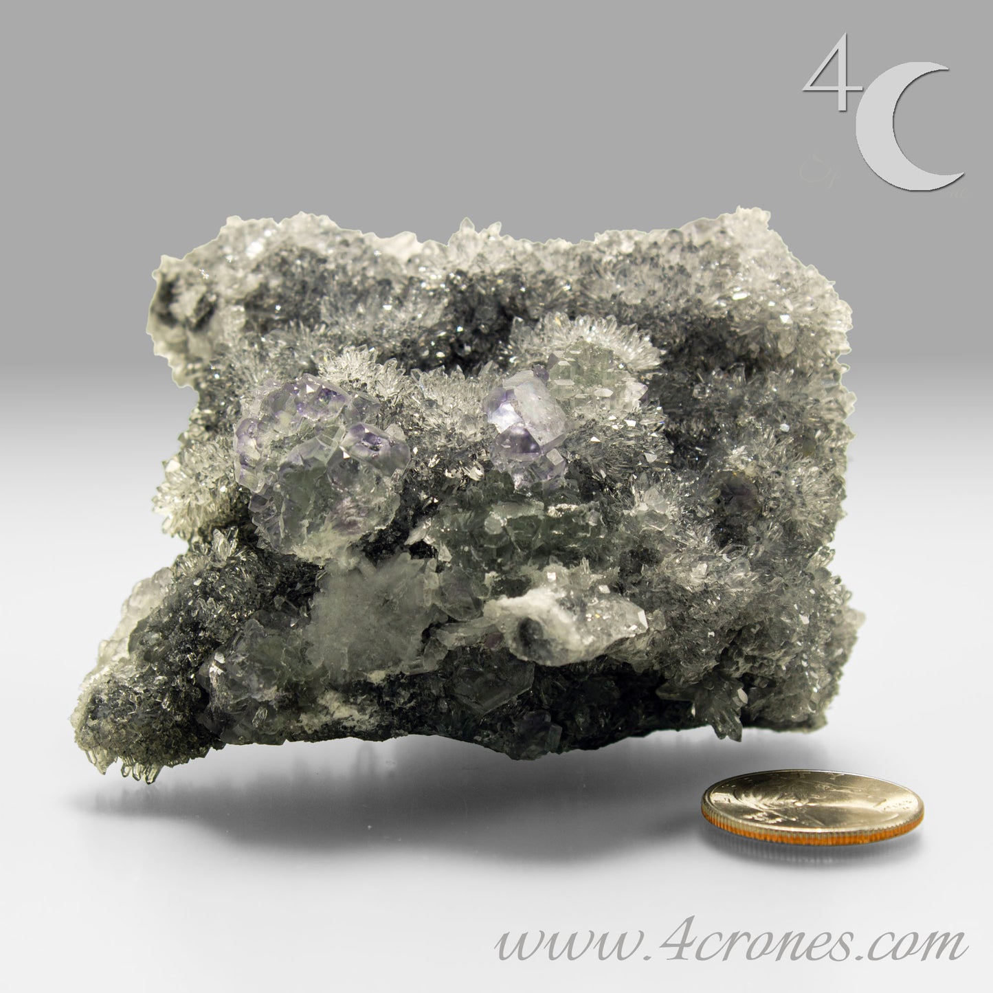 These beautiful green fluorites have enchanting delicate blue-purple phantoms. They are nestled in a dazzling bed of sparkling needle quartz and their subtlety and color shifts under various light sources create the feeling of being on a treasure hunt. Suddenly, another purple-blue phantom fluorite crystal appears amidst the crystal-clear twinkling needle quartz points. To top it off these amazing specimens glow and fluoresce a deep Lavendar under UV light. www.4crones.com