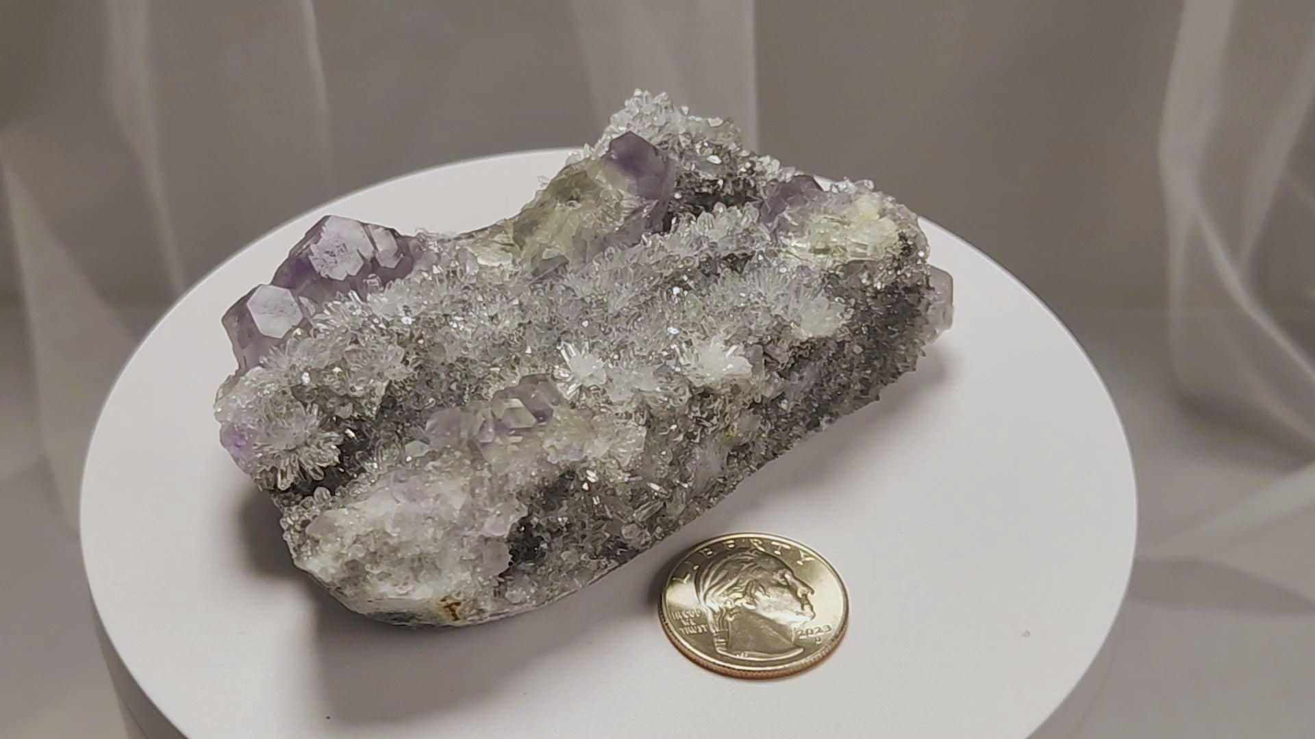 These beautiful green fluorites have enchanting delicate blue-purple phantoms. They are nestled in a dazzling bed of sparkling needle quartz and their subtlety and color shifts under various light sources create the feeling of being on a treasure hunt. Suddenly, another purple-blue phantom fluorite crystal appears amidst the crystal-clear twinkling needle quartz points. To top it off these amazing specimens glow and fluoresce a deep Lavendar under UV light. www.4crones.com